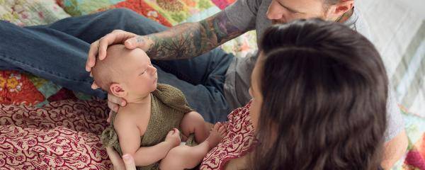 Father and mother looking lovingly at newborn baby